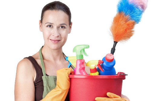 Professional house cleaner tidying a living room in Newmarket